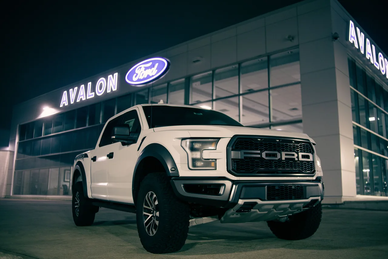 Low angle of modern pickup car with label on bumper on parking lot near retailing salon
