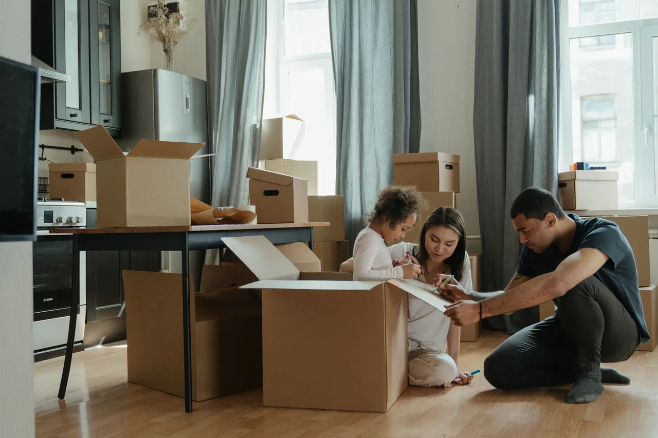A family unpacks moving boxes in their new home kitchen, creating a cozy atmosphere