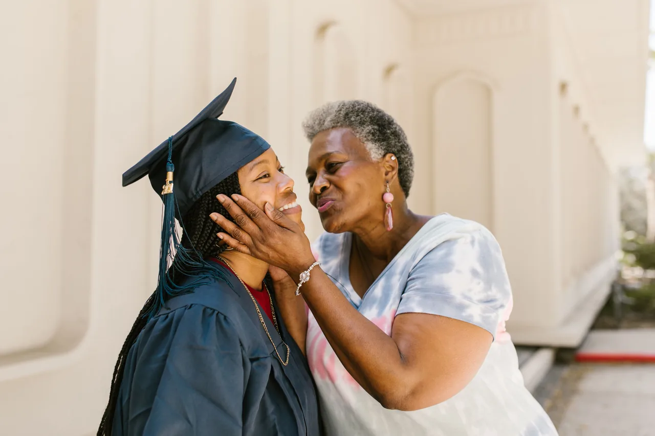 A touching moment between mother and daughter celebrating graduation outdoors