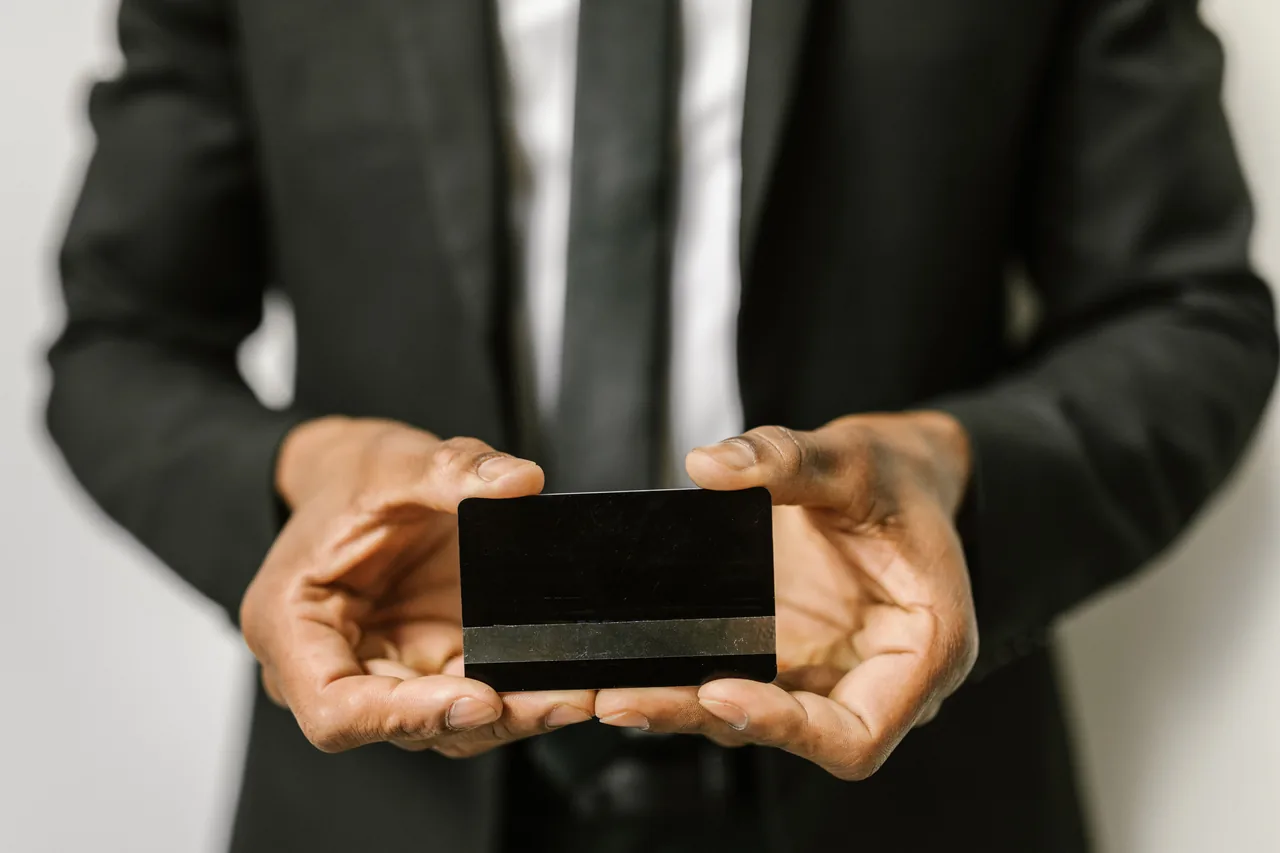Close-up of a businessman holding a blank credit card with both hands, emphasizing finance