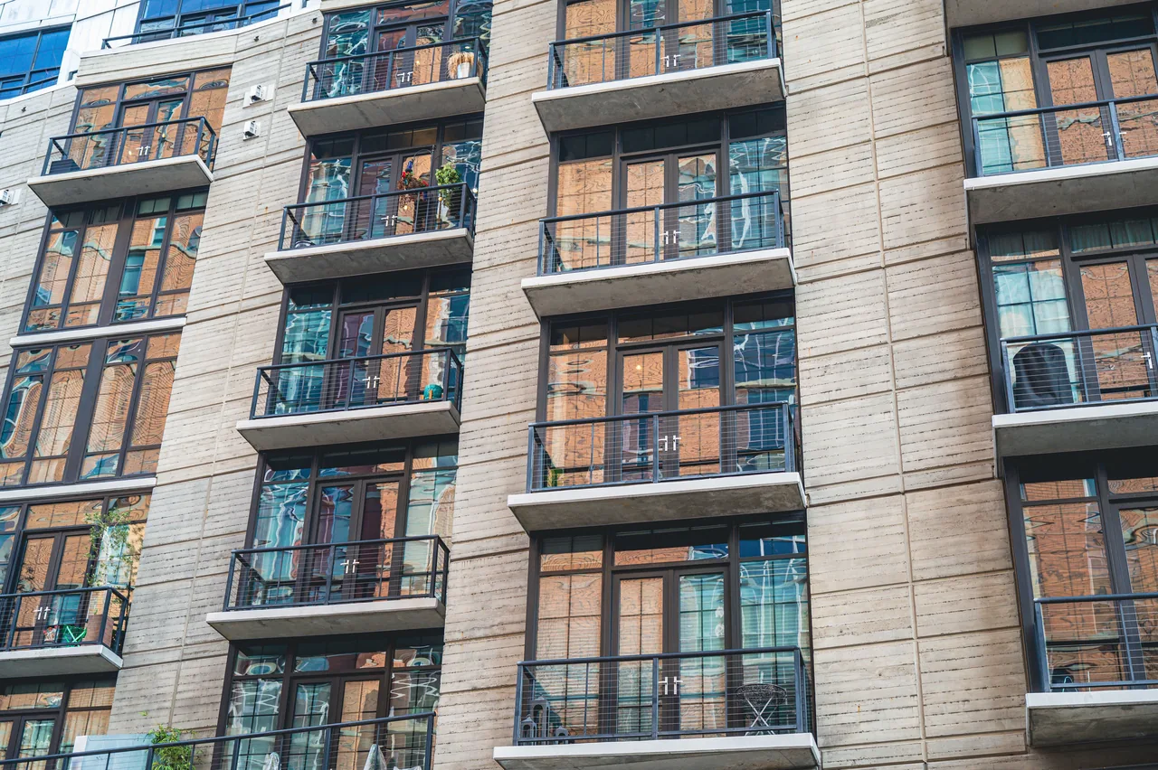Contemporary apartment building exterior with concrete facade and glass balconies