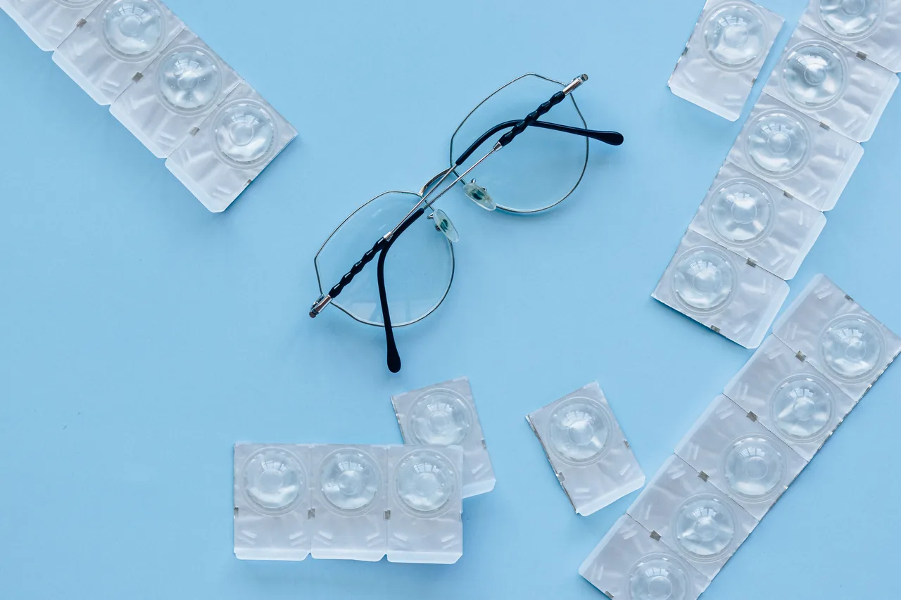 Eyeglasses and contact lenses on a blue background. Concept of eye care and vision correction