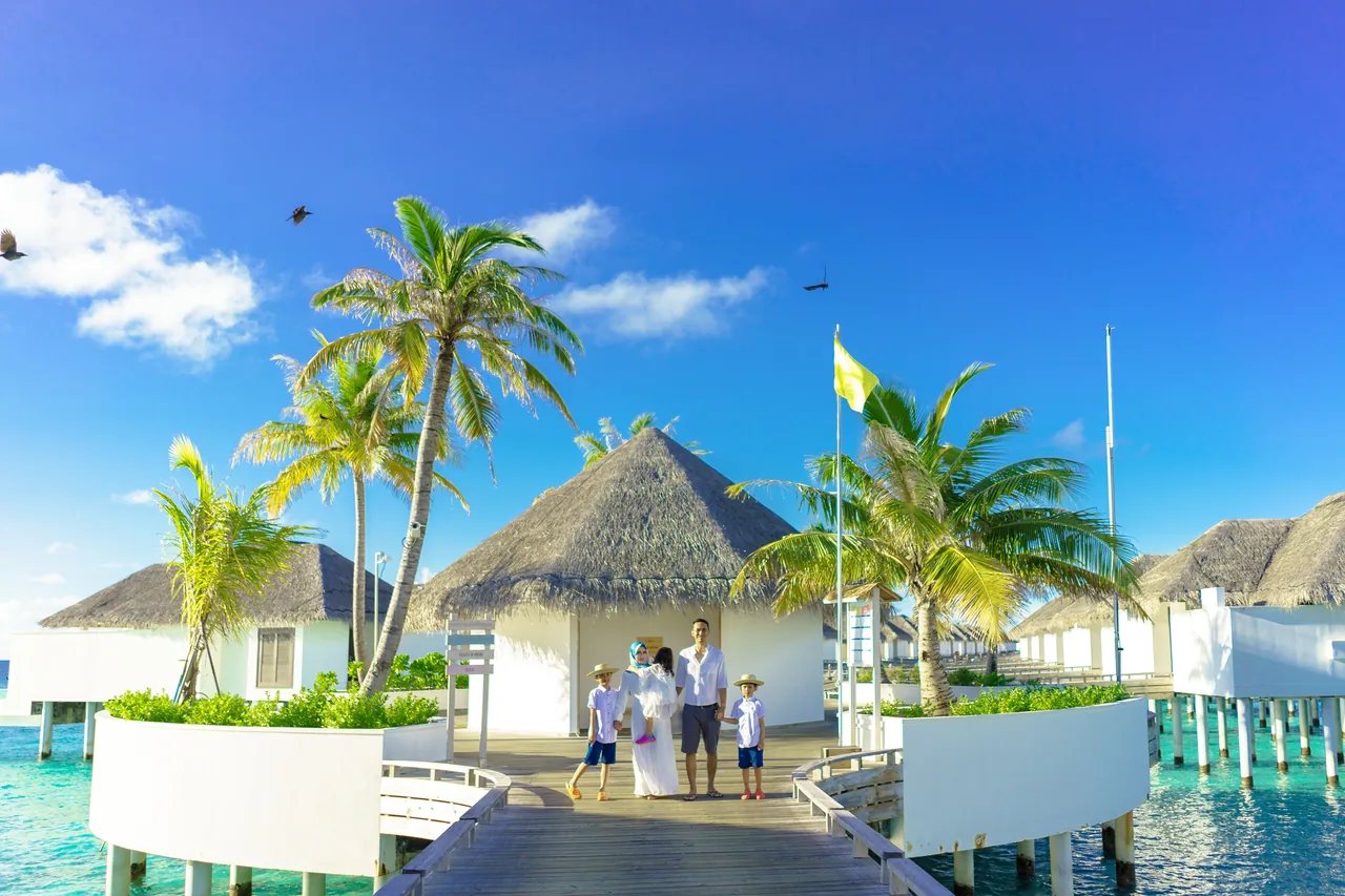 A family enjoys a sunny day at a luxurious overwater resort in a tropical paradise