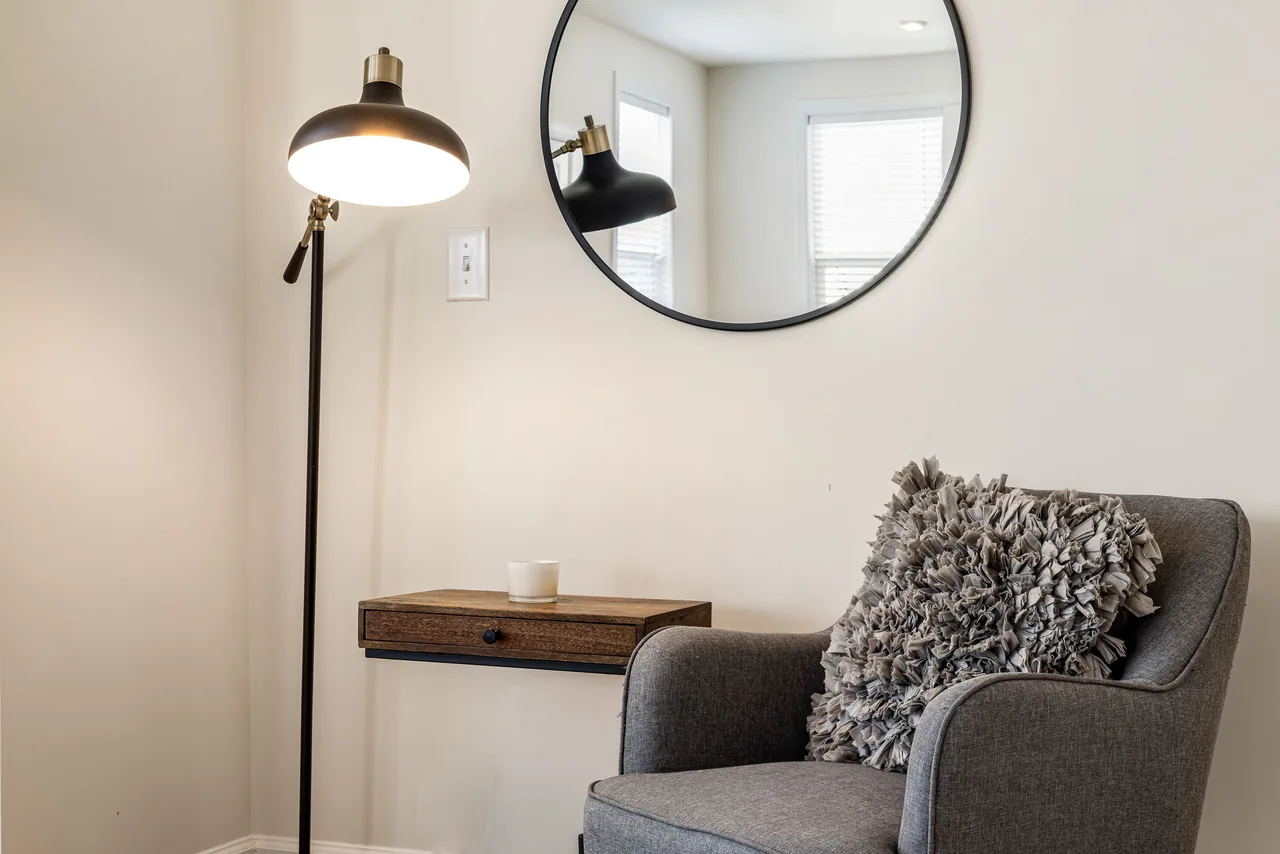 Comfortable corner with armchair, wooden shelf, and lamp in a modern living room