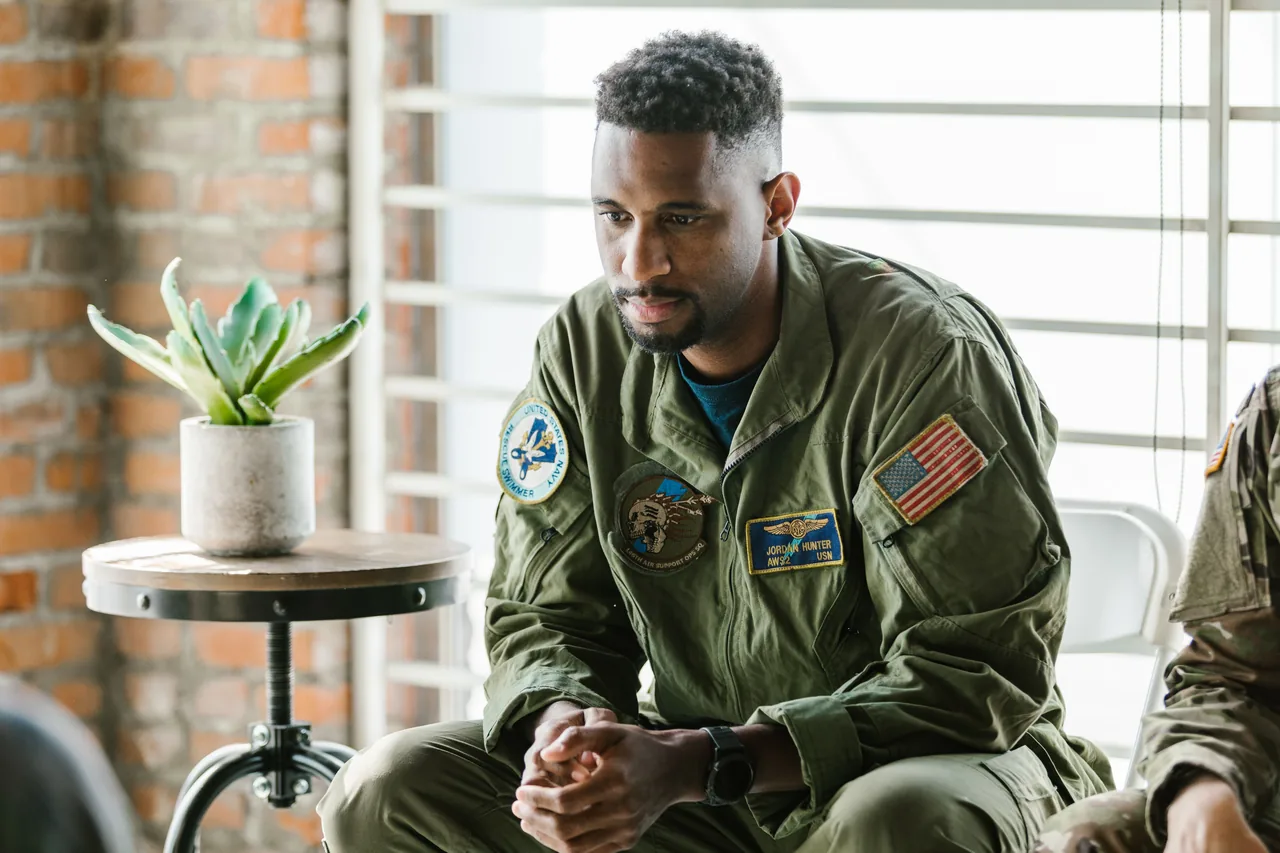 Thoughtful military veteran in uniform listening intently indoors