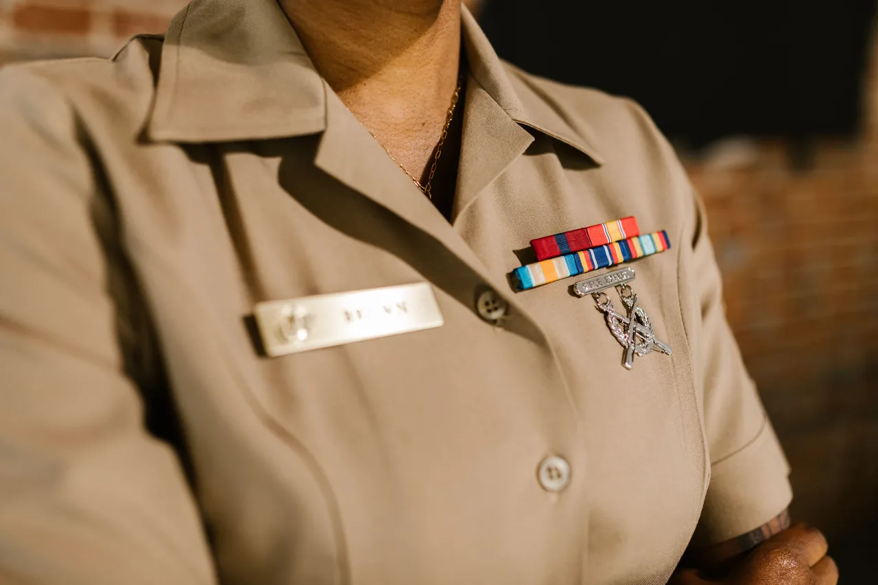 A detailed shot of a military uniform displaying medals and identification badges representing achievement and honor